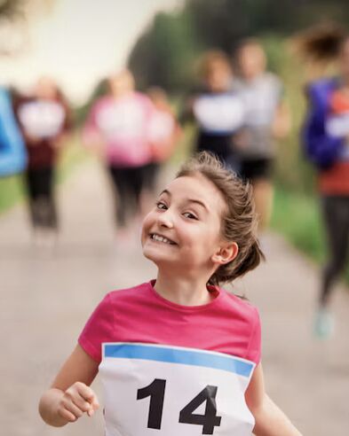 A smiling young runner wearing bib 14 during the Turkey Trot